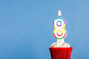 Number,8,birthday,candle,in,a,cupcake,against,a,blue